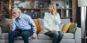 An older couple sitting on a couch.